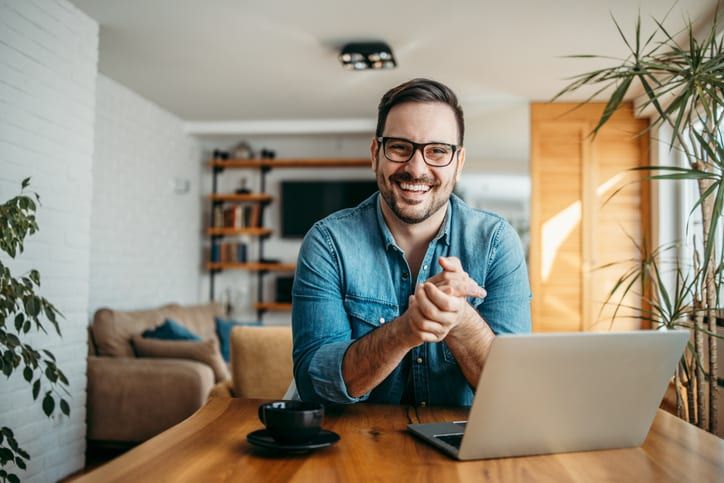 Portrait of a successful entrepreneur at cozy home office, smiling at camera.