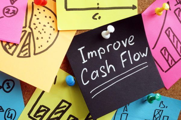 Colorful sticky notes on a corkboard with one reading "improve cash flow.