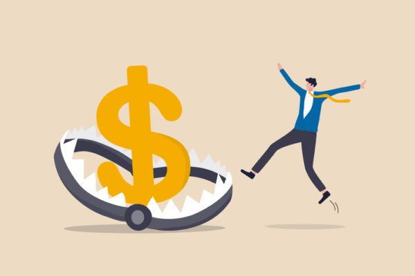 Businessman investor running and jumping into lore money pitfall or mouse trap with big money dollar sign bait.