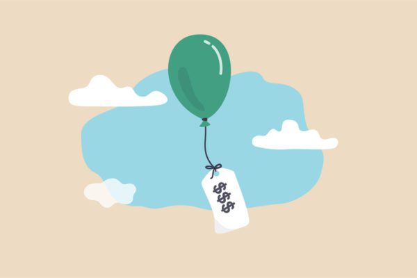 A green balloon floating in the sky carrying a note with a "good luck" message.