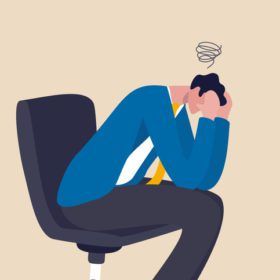 Illustration of a man in a blue suit sitting with his head in his hand, displaying stress or frustration.