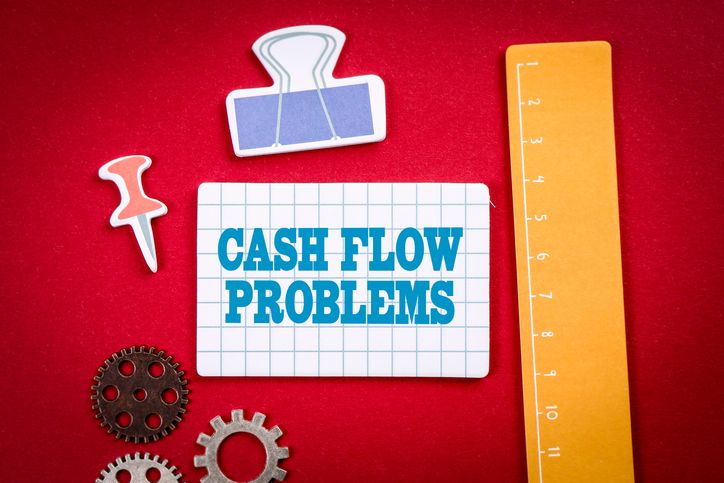 Cash Flow Problems. Office and learning supplies on a red background.