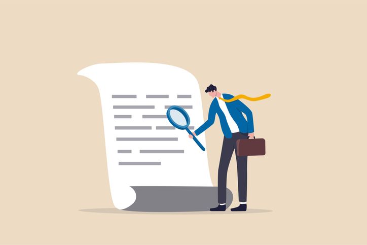 Illustration of a business person holding a briefcase and examining a document with a magnifying glass, symbolizing careful review to prevent invoice fraud