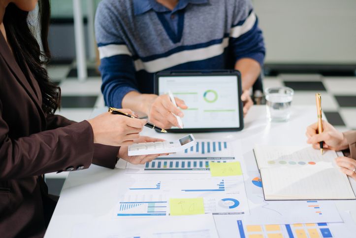 Businessman and team analyzing financial statement to improve working capital management.