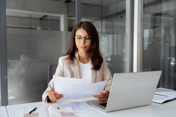 B2B business owner reviewing invoices and cash flow for accounts receivable factoring.